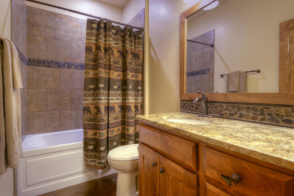 Bathroom - transitional beige tile and stone tile concrete floor bathroom idea in Denver with an undermount sink, shaker cabinets, medium tone wood cabinets, wood countertops, a one-piece toilet and beige walls
