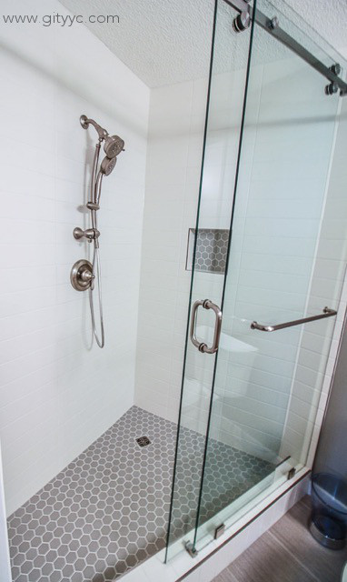 Photo of a small classic ensuite bathroom in Calgary with shaker cabinets, grey cabinets, an alcove shower, a two-piece toilet, beige tiles, ceramic tiles, grey walls, vinyl flooring, a built-in sink and laminate worktops.