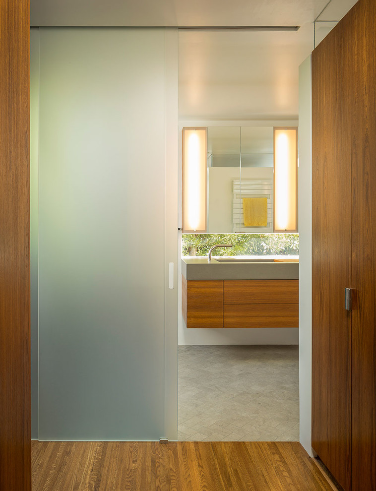 Kleines Modernes Badezimmer En Suite mit integriertem Waschbecken, flächenbündigen Schrankfronten, hellbraunen Holzschränken, Beton-Waschbecken/Waschtisch, grauen Fliesen, Keramikfliesen, weißer Wandfarbe und braunem Holzboden in San Francisco