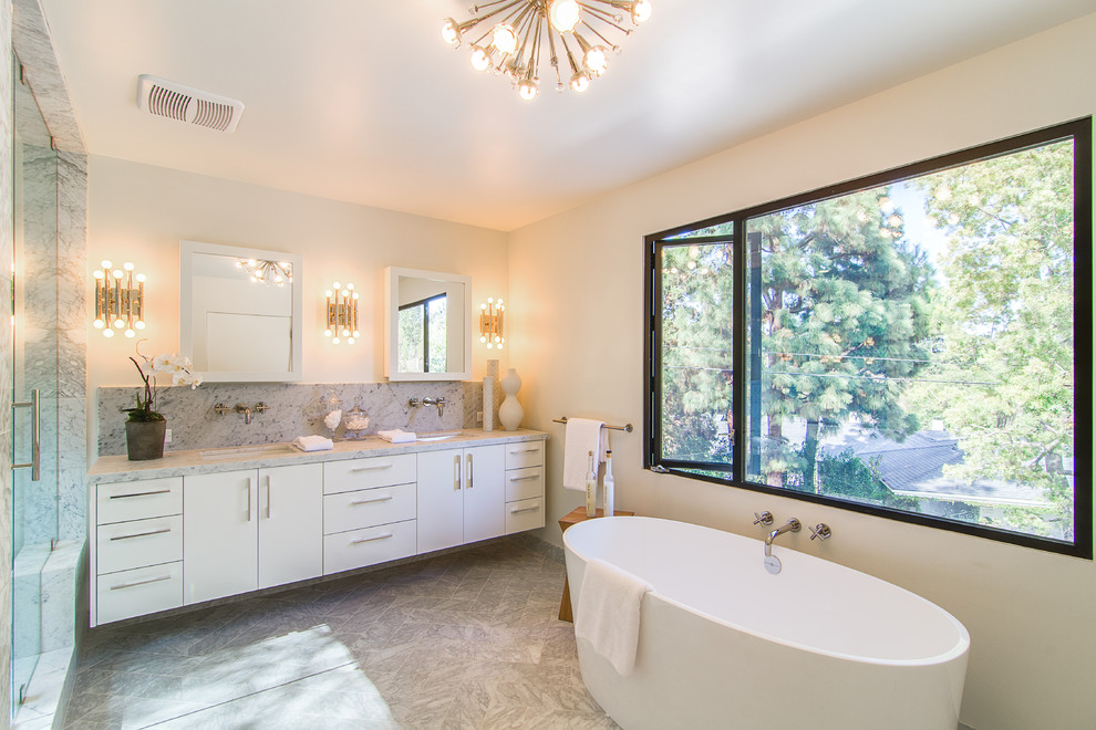 Стильный дизайн: главная ванная комната в современном стиле с плоскими фасадами, белыми фасадами, отдельно стоящей ванной, серой плиткой, врезной раковиной, серым полом и серой столешницей - последний тренд