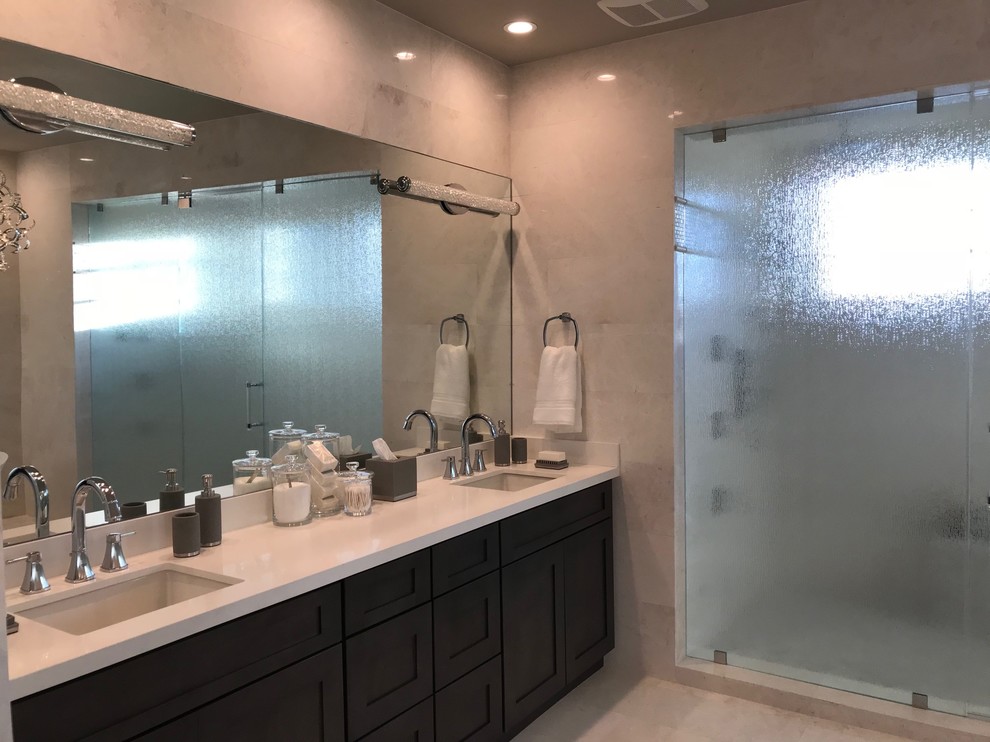 Inspiration for a large contemporary ensuite bathroom in Miami with shaker cabinets, dark wood cabinets, a freestanding bath, a double shower, a two-piece toilet, beige tiles, porcelain tiles, grey walls, porcelain flooring, a submerged sink, engineered stone worktops, beige floors, a hinged door and white worktops.