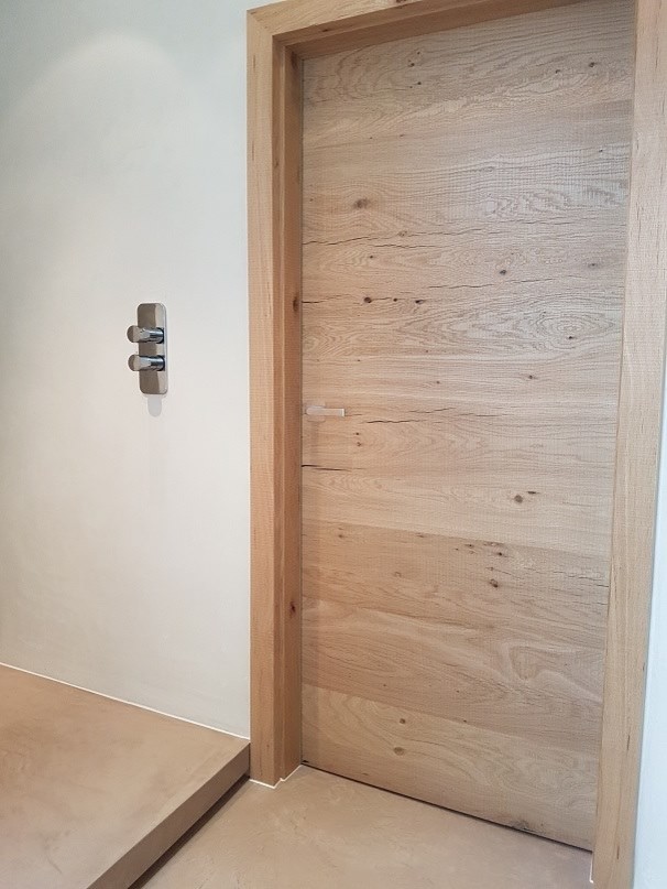 Medelhavsstil inredning av ett en-suite badrum, med en öppen dusch, en vägghängd toalettstol, beige väggar, ett konsol handfat, träbänkskiva, brunt golv och med dusch som är öppen