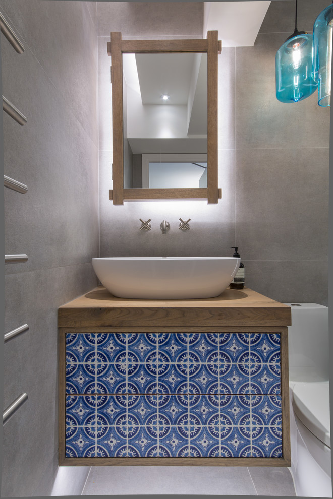 Idee per una piccola stanza da bagno per bambini bohémian con ante in legno scuro, doccia aperta, WC monopezzo, piastrelle blu, pareti grigie e top in legno