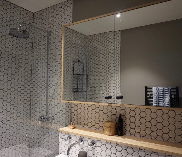 Design ideas for a medium sized family bathroom in London with flat-panel cabinets, black cabinets, a walk-in shower, a wall mounted toilet, white tiles, ceramic tiles, grey walls, ceramic flooring, a console sink, brown floors and an open shower.