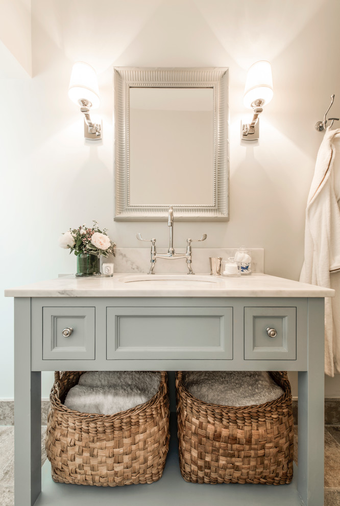 Inspiration pour une salle de bain traditionnelle avec un lavabo encastré, un placard avec porte à panneau encastré et un plan de toilette en marbre.