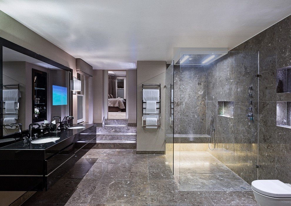 Aménagement d'une salle de bain principale contemporaine avec un placard à porte plane, des portes de placard noires, une douche à l'italienne, un carrelage gris, un mur gris, un lavabo encastré et aucune cabine.