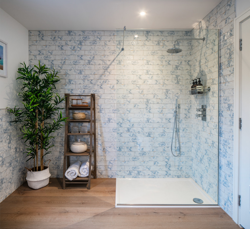 Foto de cuarto de baño clásico renovado con ducha esquinera, baldosas y/o azulejos azules, baldosas y/o azulejos blancos, paredes blancas, suelo de madera en tonos medios, suelo marrón y ducha abierta