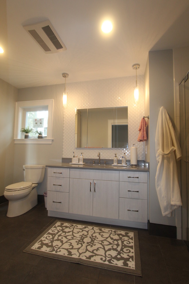 This is an example of a medium sized modern bathroom in Boston with flat-panel cabinets, white cabinets, a built-in shower, a two-piece toilet, white tiles, ceramic tiles, grey walls, porcelain flooring, a submerged sink, engineered stone worktops, grey floors and a hinged door.