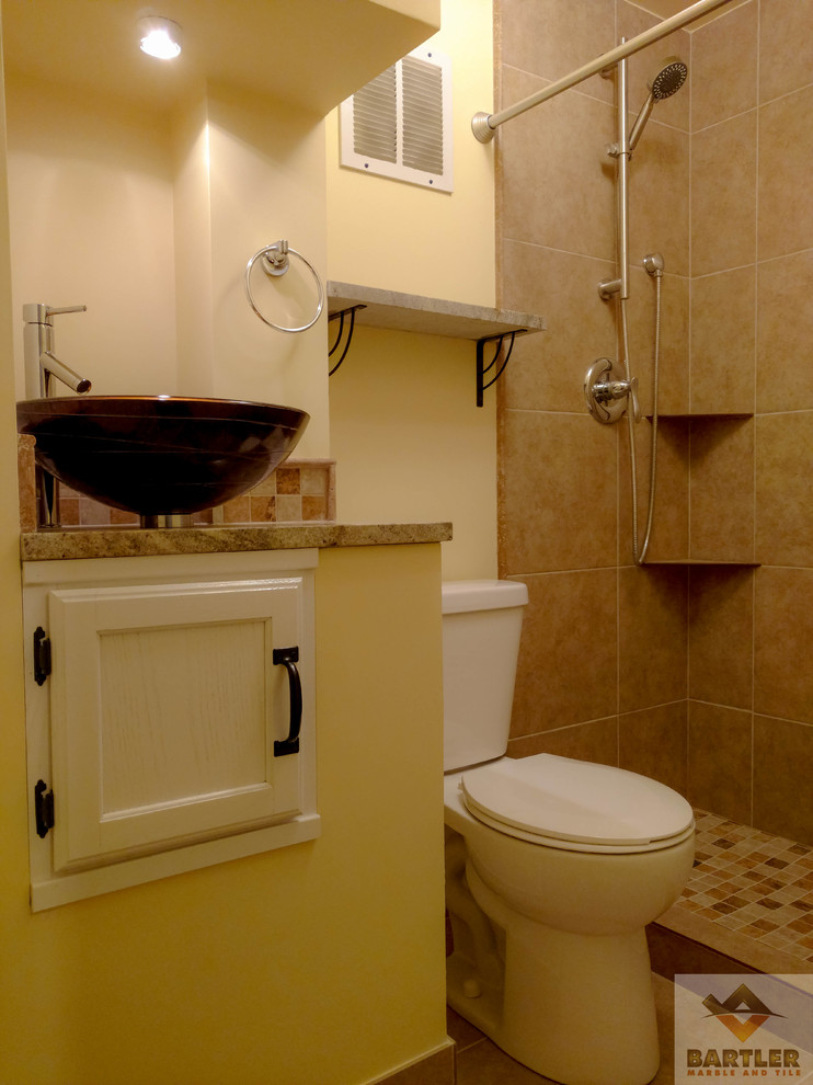 Aménagement d'une petite salle de bain bord de mer avec un placard avec porte à panneau encastré, des portes de placard blanches, WC à poser, un carrelage marron, des carreaux de céramique, un mur jaune, un lavabo de ferme et un plan de toilette en quartz.