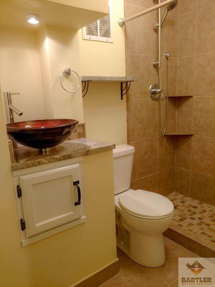 Inredning av ett maritimt litet badrum med dusch, med luckor med infälld panel, vita skåp, en dusch i en alkov, en toalettstol med hel cisternkåpa, brun kakel, keramikplattor, gula väggar, ett piedestal handfat och bänkskiva i kvartsit
