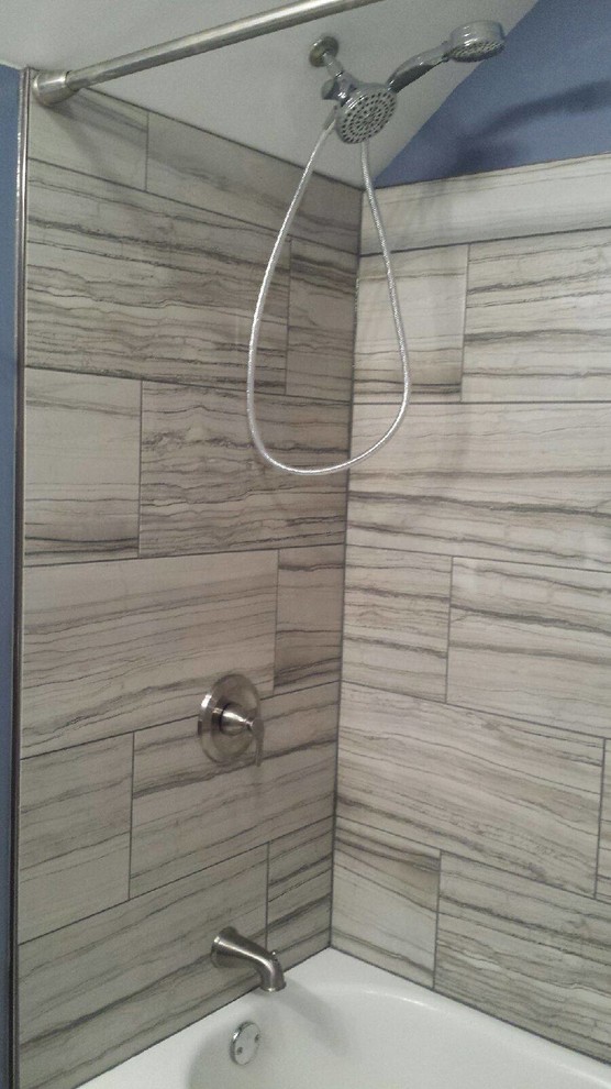 Diseño de cuarto de baño principal moderno de tamaño medio con armarios con paneles lisos, puertas de armario blancas, combinación de ducha y bañera, baldosas y/o azulejos grises y ducha con cortina
