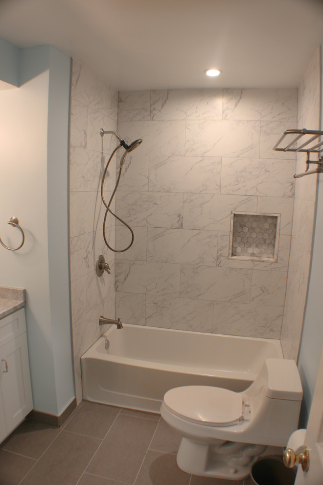 Exempel på ett mellanstort klassiskt en-suite badrum, med skåp i shakerstil, vita skåp, ett badkar i en alkov, en dusch/badkar-kombination, en toalettstol med hel cisternkåpa, svart och vit kakel, keramikplattor, blå väggar, klinkergolv i keramik, ett undermonterad handfat och marmorbänkskiva