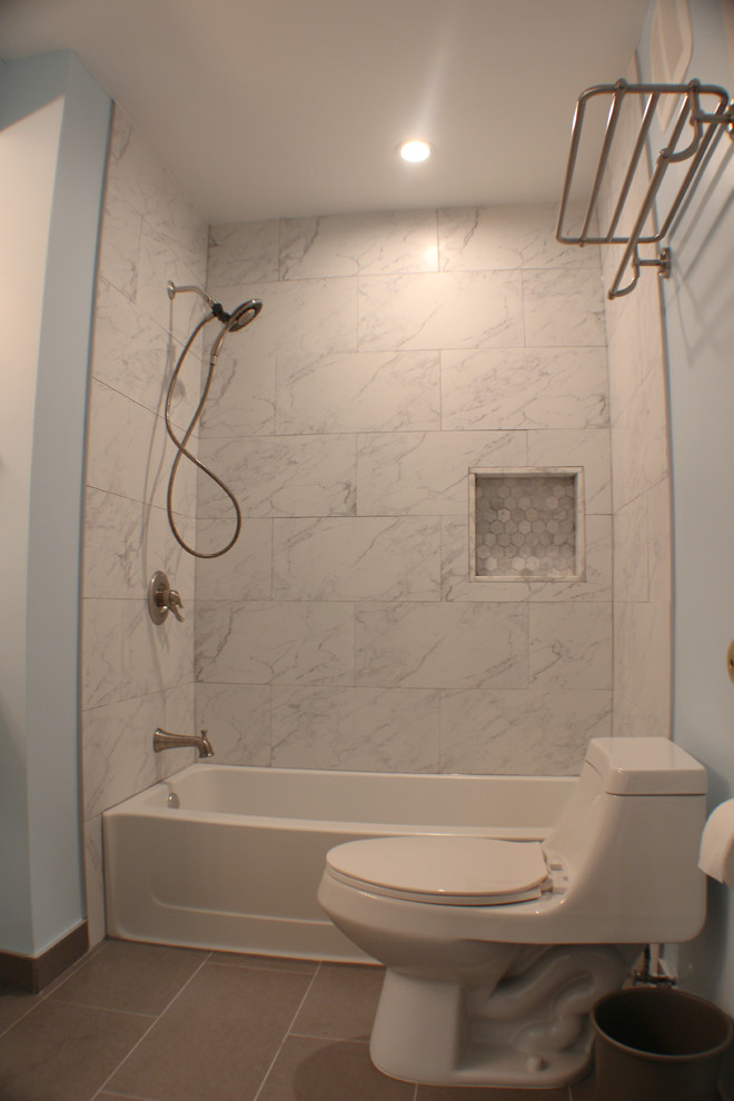 Cette image montre une salle de bain principale traditionnelle de taille moyenne avec un placard à porte shaker, des portes de placard blanches, une baignoire en alcôve, un combiné douche/baignoire, WC à poser, un carrelage noir et blanc, des carreaux de céramique, un mur bleu, un sol en carrelage de céramique, un lavabo encastré et un plan de toilette en marbre.