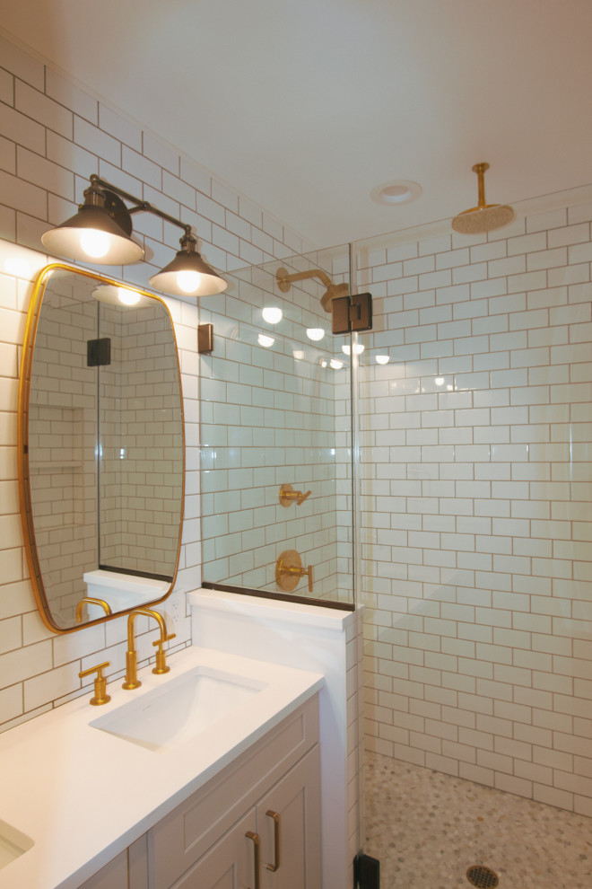 This is an example of a medium sized bohemian ensuite bathroom in Philadelphia with recessed-panel cabinets, white cabinets, an alcove shower, white tiles, metro tiles, a submerged sink, engineered stone worktops, an open shower, white worktops, a one-piece toilet, white walls, porcelain flooring and brown floors.