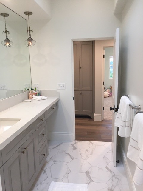 Inspiration for a small transitional 3/4 marble floor and white floor bathroom remodel in Los Angeles with dark wood cabinets, gray walls, an undermount sink, raised-panel cabinets, quartz countertops and white countertops