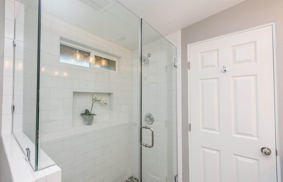 На фото: ванная комната среднего размера в современном стиле с угловым душем, белой плиткой, плиткой кабанчик, серыми стенами, душем с распашными дверями, плоскими фасадами, белыми фасадами, полом из керамической плитки, врезной раковиной и разноцветным полом