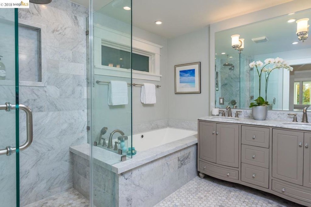 Medium sized traditional ensuite bathroom in San Francisco with raised-panel cabinets, grey cabinets, a built-in bath, a corner shower, a two-piece toilet, grey tiles, marble tiles, grey walls, marble flooring, a submerged sink, marble worktops, grey floors, a hinged door, grey worktops, double sinks and a built in vanity unit.