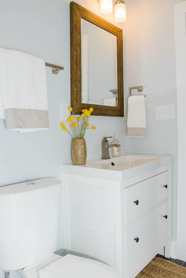 Modelo de cuarto de baño clásico renovado pequeño con armarios tipo mueble, puertas de armario blancas, sanitario de dos piezas, paredes grises, aseo y ducha, lavabo integrado, encimera de cuarzo compacto, encimeras blancas, suelo de baldosas de porcelana y suelo gris