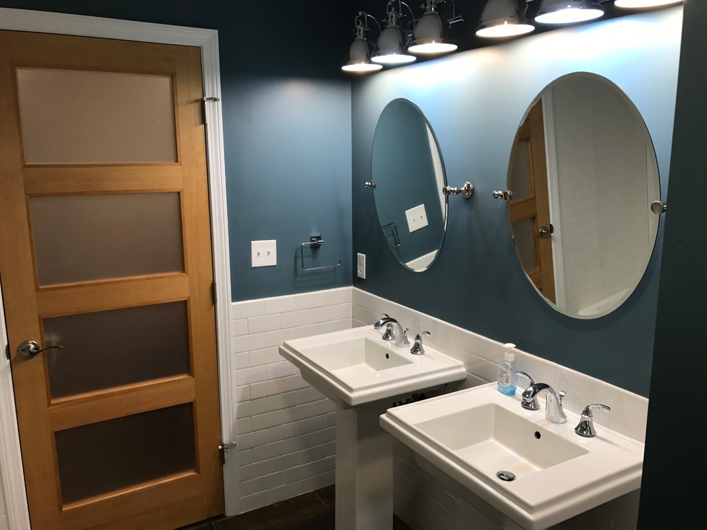 Klassisk inredning av ett mellanstort badrum med dusch, med en hörndusch, vit kakel, tunnelbanekakel, blå väggar, mörkt trägolv och ett piedestal handfat