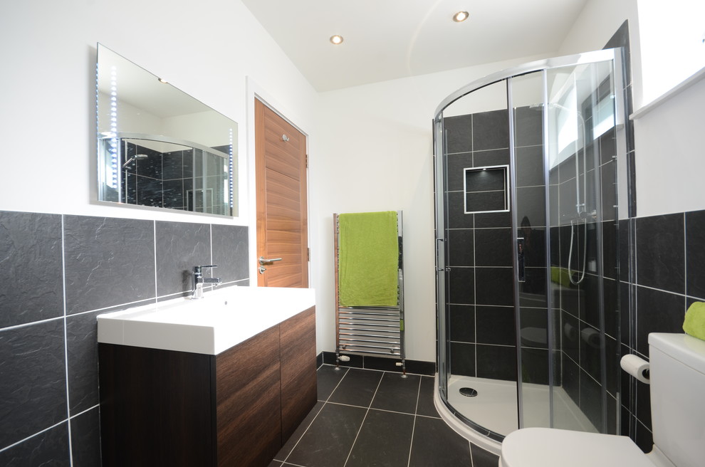 На фото: главная ванная комната среднего размера в современном стиле с настольной раковиной, плоскими фасадами, темными деревянными фасадами, угловым душем, унитазом-моноблоком, черной плиткой и белыми стенами