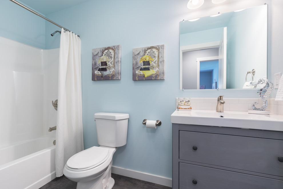 Aménagement d'une salle d'eau classique de taille moyenne avec un placard en trompe-l'oeil, des portes de placard grises, une baignoire en alcôve, un combiné douche/baignoire, WC séparés, un mur bleu, sol en stratifié, un lavabo intégré, un plan de toilette en quartz modifié, un sol marron, une cabine de douche avec un rideau et un plan de toilette blanc.