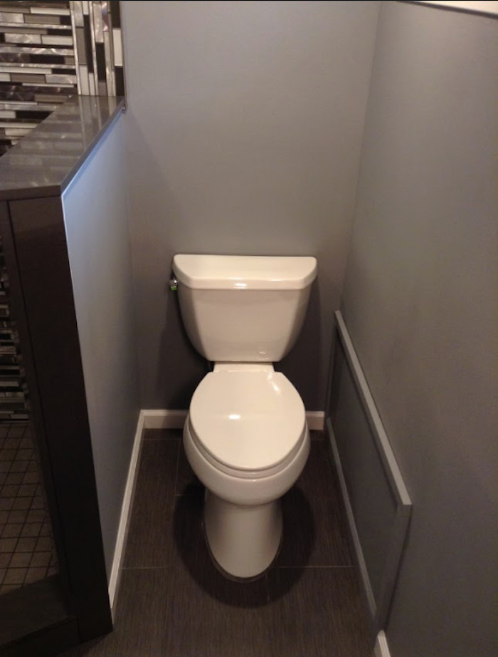 Kleine Moderne Gästetoilette mit Toilette mit Aufsatzspülkasten, beigen Fliesen, schwarz-weißen Fliesen, grauen Fliesen, Glasfliesen, grauer Wandfarbe, dunklem Holzboden und braunem Boden in New York