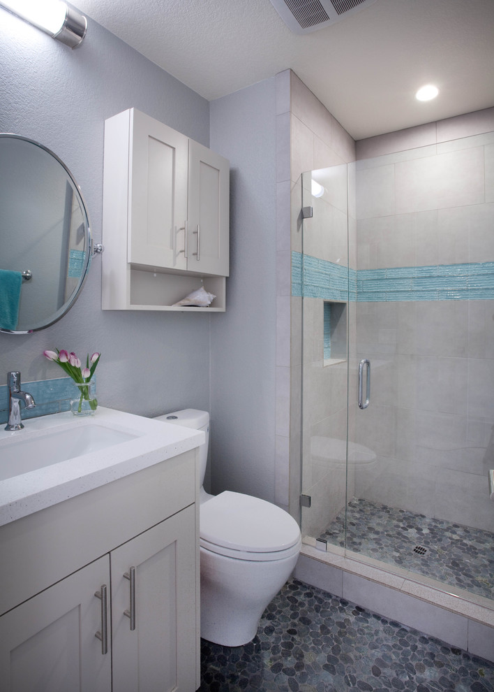 На фото: ванная комната среднего размера в стиле модернизм с плоскими фасадами, серыми фасадами, душем в нише, раздельным унитазом, серой плиткой, серыми стенами, полом из галечной плитки, душевой кабиной, раковиной с несколькими смесителями, разноцветным полом и душем с распашными дверями с
