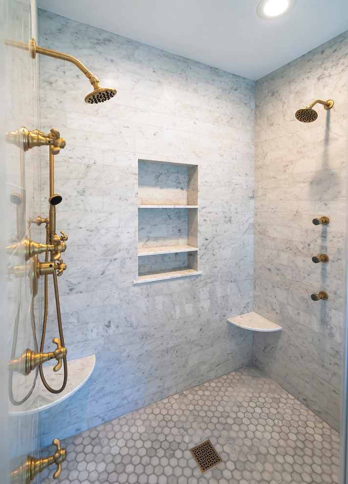 Inredning av ett amerikanskt mellanstort vit vitt badrum, med luckor med profilerade fronter, blå skåp, ett fristående badkar, en dubbeldusch, vit kakel, marmorkakel, grå väggar, marmorgolv, ett undermonterad handfat, marmorbänkskiva, vitt golv och dusch med gångjärnsdörr
