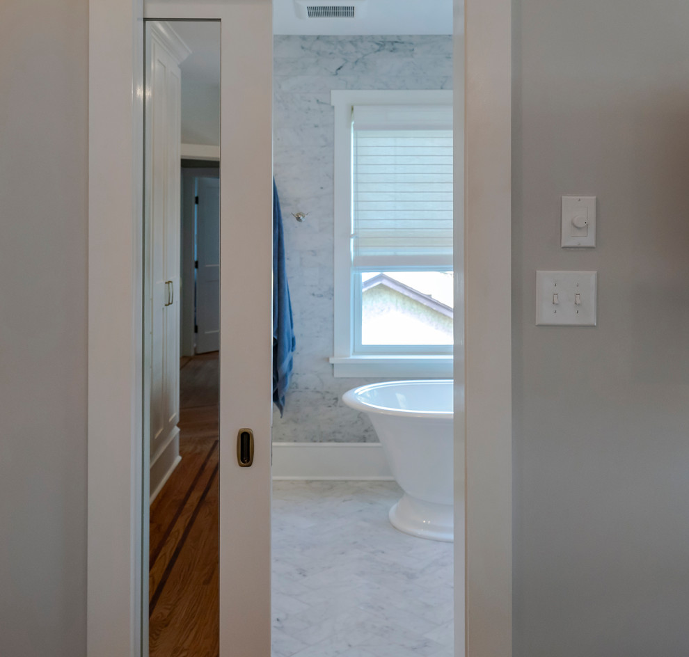 На фото: ванная комната среднего размера в стиле кантри с фасадами с декоративным кантом, синими фасадами, отдельно стоящей ванной, двойным душем, белой плиткой, мраморной плиткой, серыми стенами, мраморным полом, врезной раковиной, мраморной столешницей, белым полом, душем с распашными дверями и белой столешницей