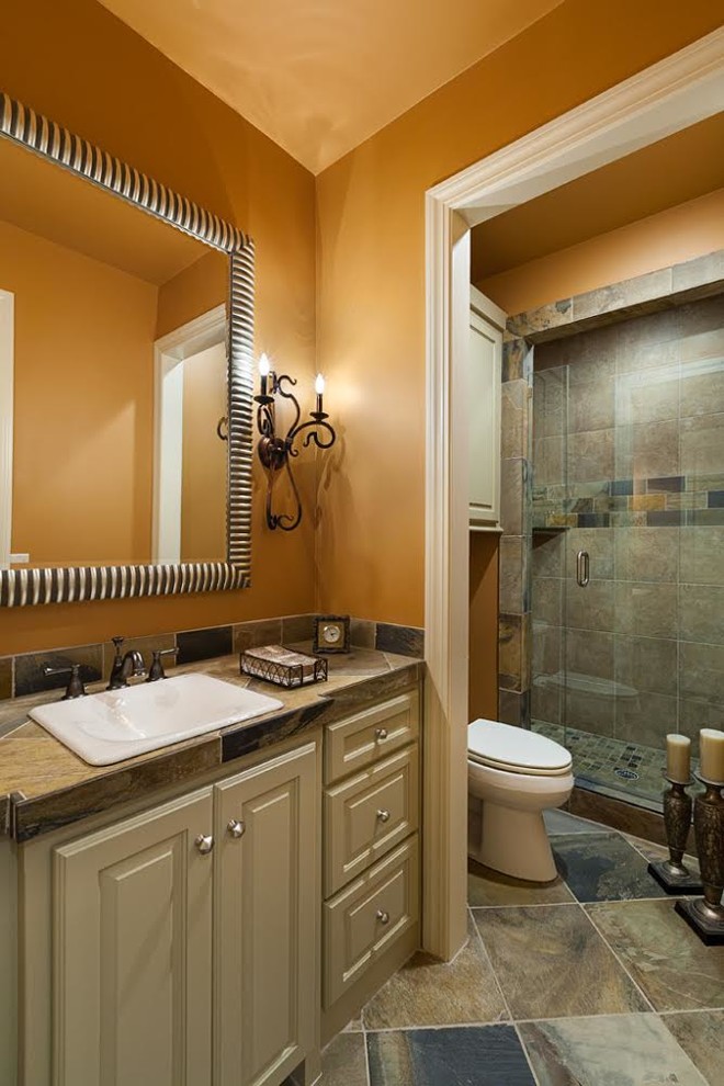 Idées déco pour une salle de bain de taille moyenne avec un lavabo intégré, un placard avec porte à panneau surélevé, des portes de placard beiges, un plan de toilette en carrelage, WC à poser, un carrelage marron, des carreaux de céramique, un mur orange et un sol en carrelage de céramique.