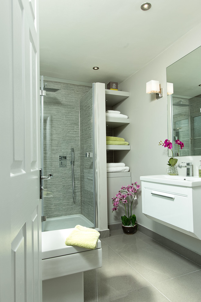 Ispirazione per una stanza da bagno con doccia chic con ante lisce, ante bianche, doccia ad angolo, piastrelle grigie, pareti grigie e lavabo a consolle