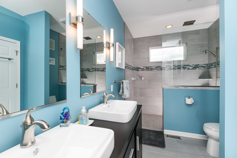 Idées déco pour une grande salle de bain principale classique avec un placard à porte plane, des portes de placard noires, une douche ouverte, WC séparés, un carrelage gris, des carreaux de céramique, un mur bleu, un sol en carrelage de céramique et une grande vasque.