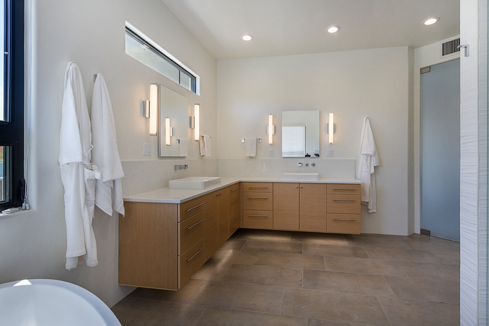 Large trendy master multicolored tile and glass tile porcelain tile and gray floor bathroom photo in Phoenix with flat-panel cabinets, light wood cabinets, a one-piece toilet, white walls, a vessel sink, quartz countertops, a hinged shower door and white countertops
