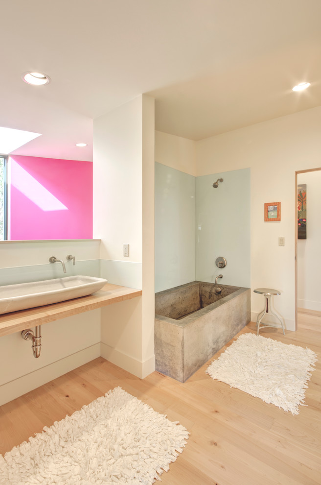 ポートランドにあるコンテンポラリースタイルのおしゃれな浴室 (ベッセル式洗面器、アルコーブ型浴槽、木製洗面台、シャワー付き浴槽	) の写真
