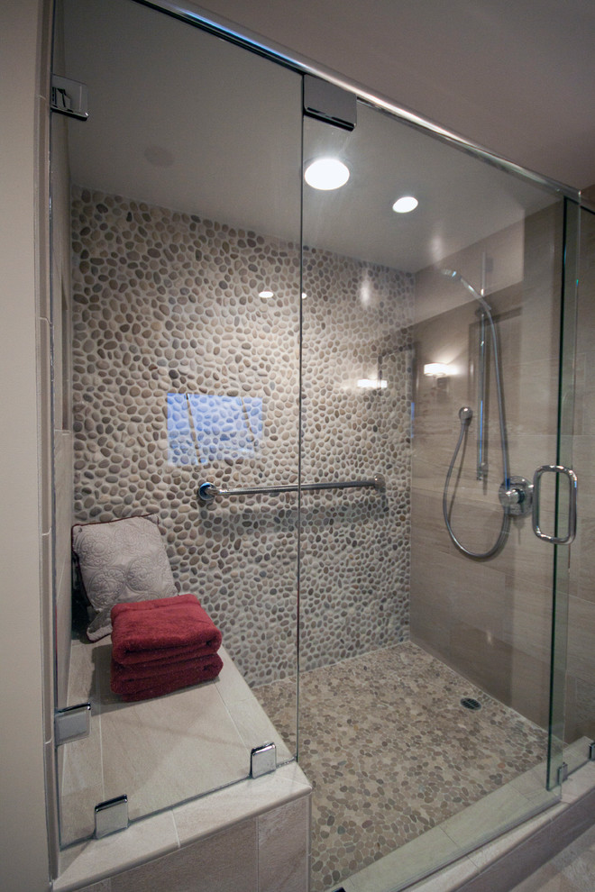 Modern inredning av ett badrum, med beige kakel, kakel i småsten, beige väggar, flerfärgat golv och dusch med gångjärnsdörr