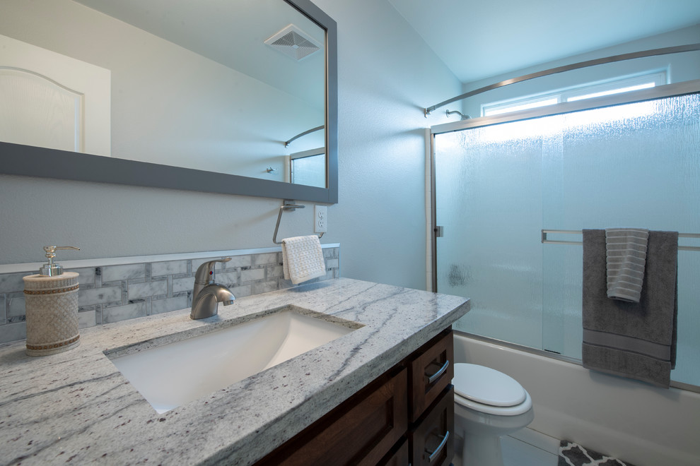 Example of a small arts and crafts master multicolored tile and mosaic tile porcelain tile and white floor bathroom design in Los Angeles with shaker cabinets, medium tone wood cabinets, a two-piece toilet, gray walls, an undermount sink, granite countertops and multicolored countertops