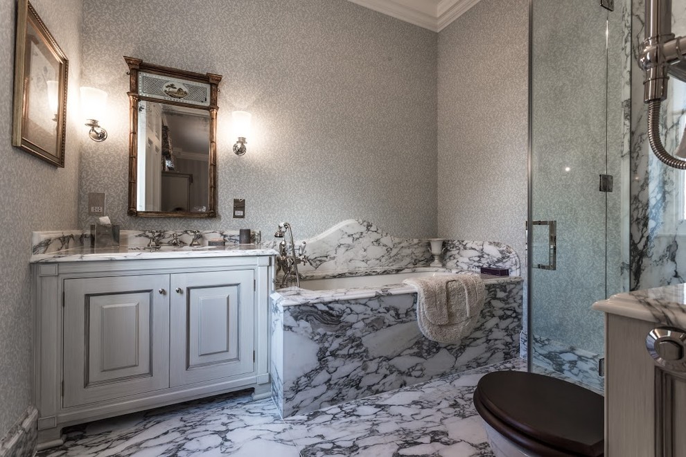 Modern inredning av ett mellanstort en-suite badrum, med ett integrerad handfat, marmorbänkskiva, ett hörnbadkar, en hörndusch, en toalettstol med hel cisternkåpa, grå väggar och marmorgolv