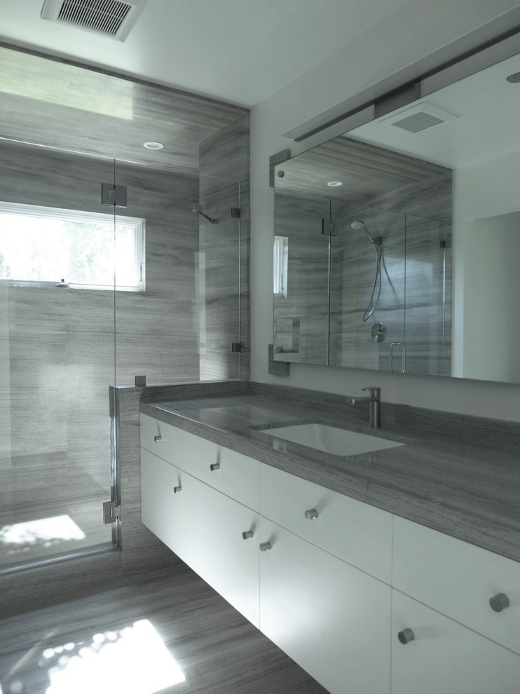 Photo of a medium sized modern bathroom in Other with flat-panel cabinets, white cabinets, an alcove shower, white walls, a submerged sink, porcelain flooring and grey tiles.