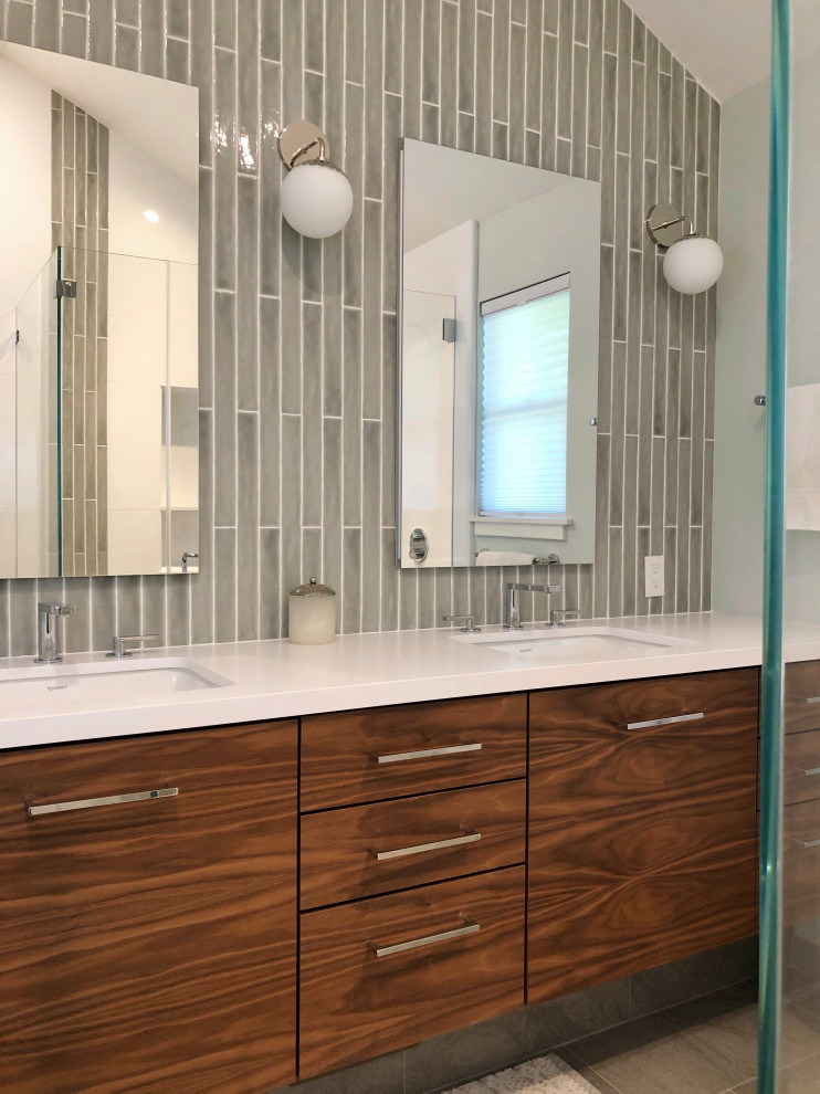 Пример оригинального дизайна: ванная комната среднего размера в стиле модернизм с плоскими фасадами, темными деревянными фасадами, угловым душем, серой плиткой, керамогранитной плиткой, полом из керамогранита, душевой кабиной, врезной раковиной, столешницей из искусственного кварца, серым полом, душем с распашными дверями, белой столешницей, тумбой под две раковины, подвесной тумбой и сводчатым потолком