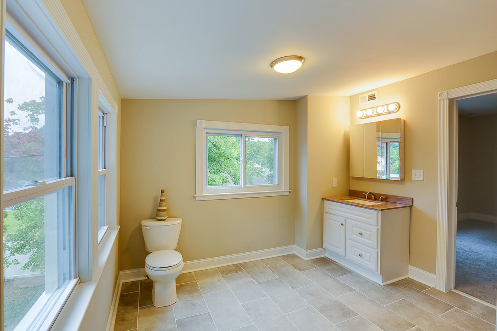 На фото: ванная комната среднего размера в классическом стиле с фасадами с выступающей филенкой, белыми фасадами, раздельным унитазом, бежевыми стенами, полом из травертина, душевой кабиной и врезной раковиной