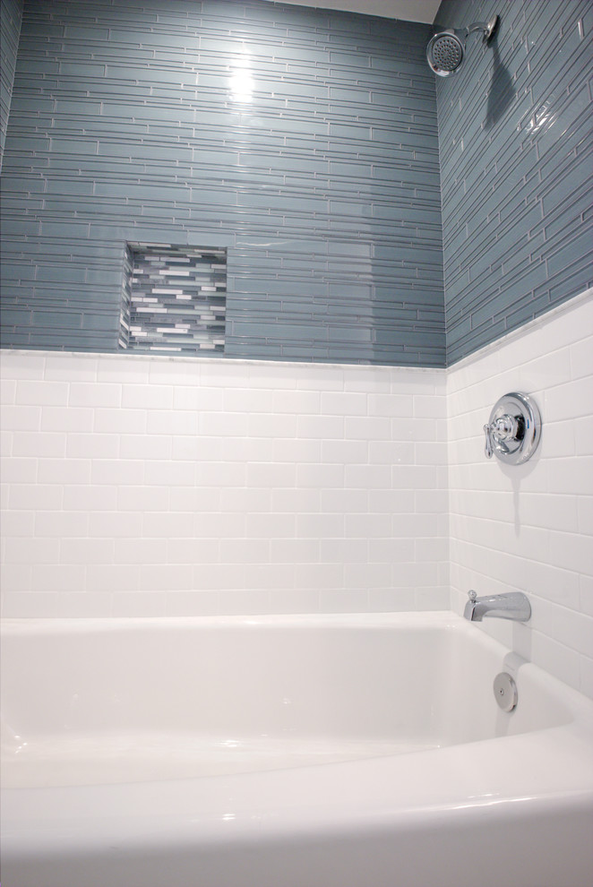 На фото: маленькая ванная комната в стиле неоклассика (современная классика) с ванной в нише, душем над ванной, синей плиткой и стеклянной плиткой для на участке и в саду с