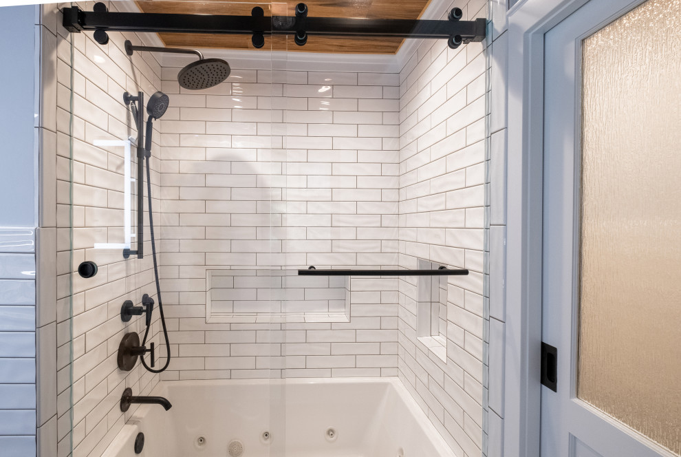 Idéer för att renovera ett mellanstort funkis svart svart en-suite badrum, med skåp i shakerstil, skåp i mellenmörkt trä, ett badkar i en alkov, en dusch/badkar-kombination, vit kakel, tunnelbanekakel, klinkergolv i porslin, ett fristående handfat, bänkskiva i akrylsten, grått golv och dusch med skjutdörr