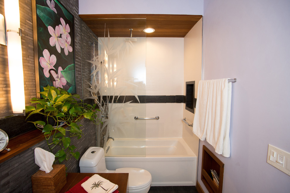 Inspiration för ett litet tropiskt badrum, med släta luckor, skåp i mörkt trä, träbänkskiva, ett badkar i en alkov, en dusch/badkar-kombination, en toalettstol med hel cisternkåpa, grå kakel, stenkakel, ett fristående handfat och skiffergolv