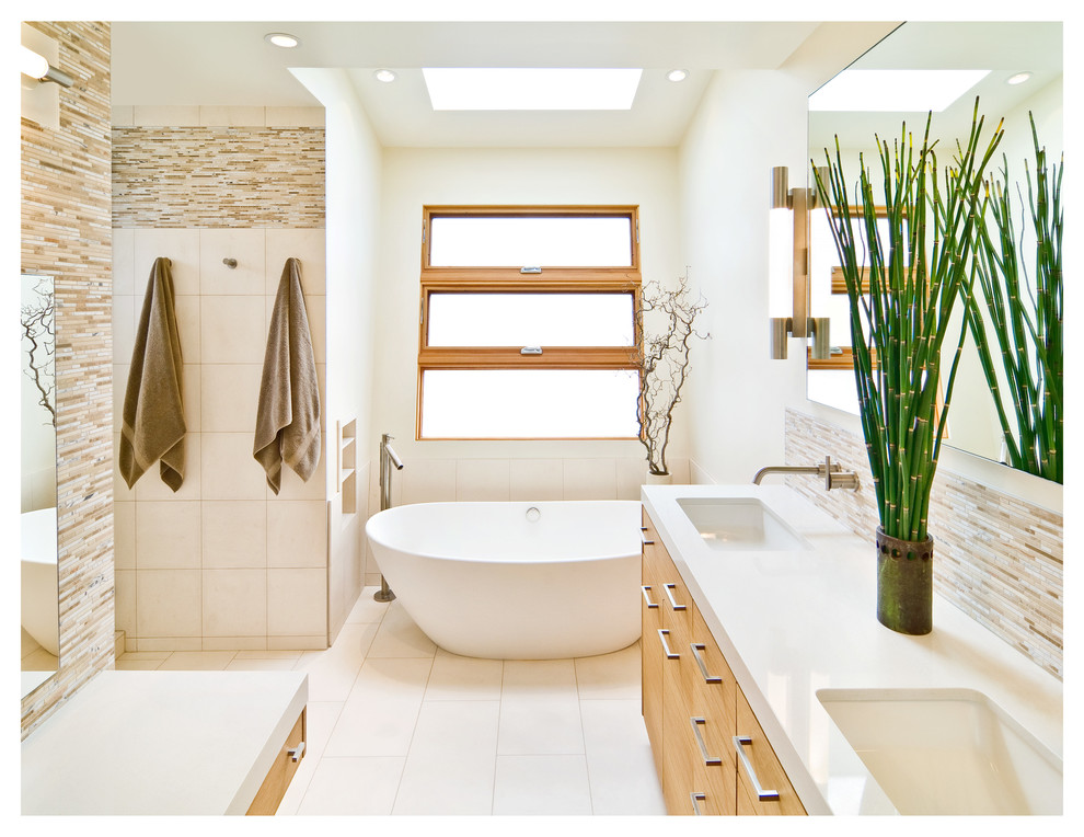 Источник вдохновения для домашнего уюта: главная ванная комната среднего размера в стиле модернизм с накладной раковиной, плоскими фасадами, светлыми деревянными фасадами, отдельно стоящей ванной, раздельным унитазом, разноцветной плиткой, белыми стенами, полом из керамогранита, бежевым полом, столешницей из гранита, тумбой под две раковины и напольной тумбой