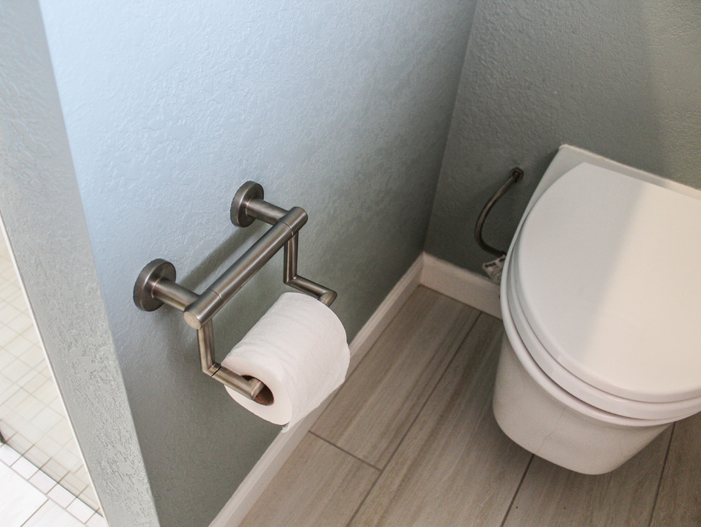 Medium sized contemporary ensuite bathroom in San Francisco with flat-panel cabinets, white cabinets, a wall mounted toilet, white tiles, ceramic tiles, green walls, porcelain flooring, a submerged sink, engineered stone worktops, beige floors, a hinged door, beige worktops and a built-in shower.