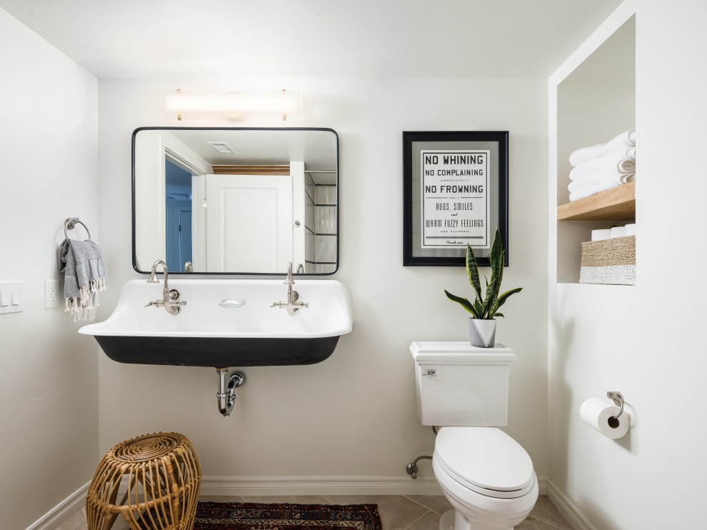 Пример оригинального дизайна: маленькая ванная комната в стиле неоклассика (современная классика) с черными фасадами, ванной в нише, душем над ванной, унитазом-моноблоком, бежевой плиткой, керамической плиткой, белыми стенами, полом из керамической плитки, подвесной раковиной, столешницей из бетона, бежевым полом, шторкой для ванной, белой столешницей, нишей, тумбой под две раковины, подвесной тумбой и душевой кабиной для на участке и в саду