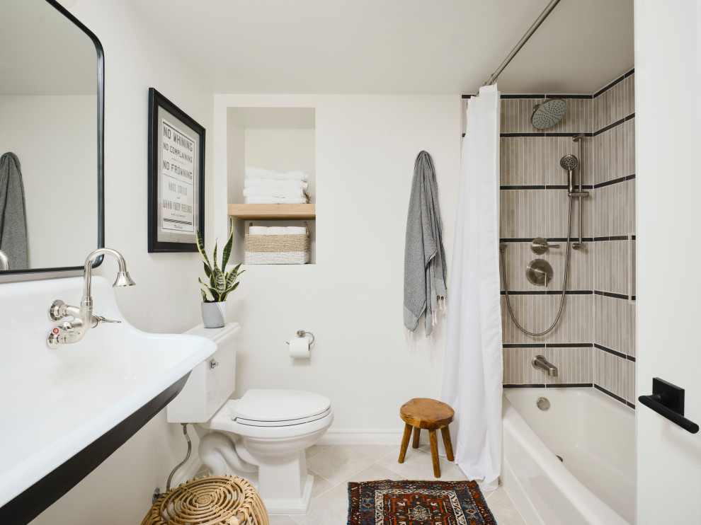 На фото: маленькая детская ванная комната в стиле модернизм с черными фасадами, ванной в нише, душем над ванной, унитазом-моноблоком, бежевой плиткой, керамической плиткой, белыми стенами, полом из керамической плитки, подвесной раковиной, столешницей из бетона, бежевым полом, шторкой для ванной, белой столешницей, нишей, тумбой под две раковины и подвесной тумбой для на участке и в саду с