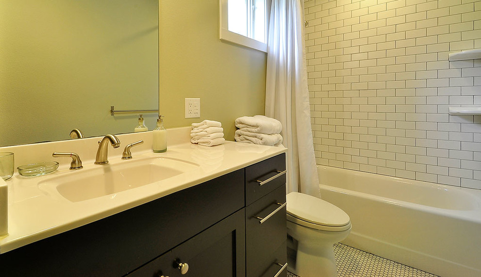 Стильный дизайн: ванная комната в современном стиле с монолитной раковиной, плоскими фасадами, темными деревянными фасадами, столешницей из ламината, накладной ванной, душем над ванной, раздельным унитазом, белой плиткой и плиткой кабанчик - последний тренд
