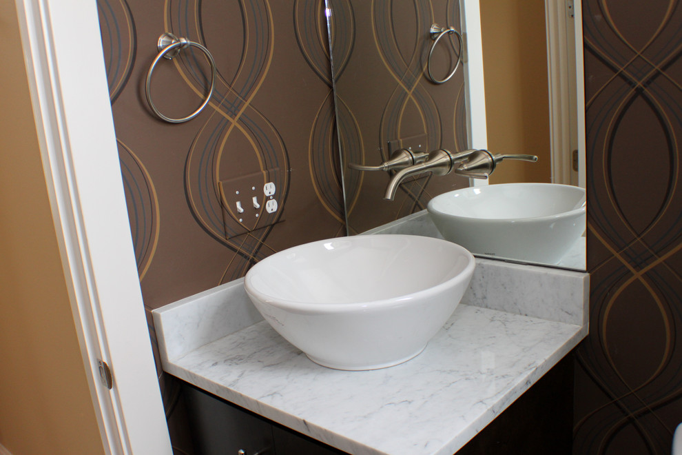 Foto di una stanza da bagno classica con lavabo a bacinella, consolle stile comò, ante in legno scuro, top in marmo e piastrelle bianche