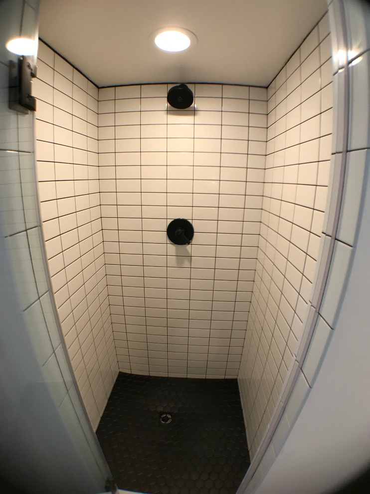 This is an example of a medium sized midcentury ensuite bathroom in Other with flat-panel cabinets, medium wood cabinets, a one-piece toilet, white tiles, metro tiles, white walls, ceramic flooring, solid surface worktops, black floors, a hinged door and white worktops.